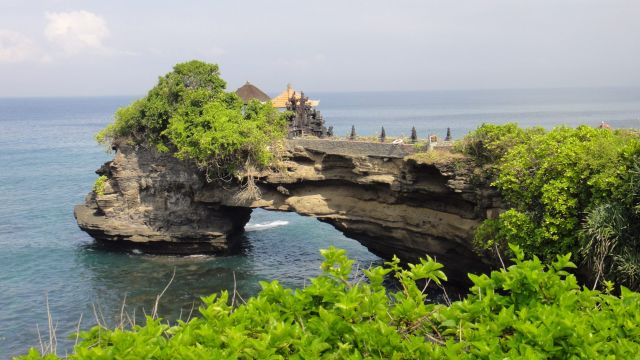 Petit temple au bout d’une arche rocheuse à Tanah Lot